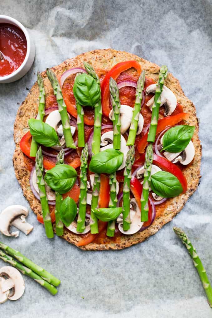 Cauliflower Pizza Crust topped with asparagus and spinach dressing| via @annabanana.co