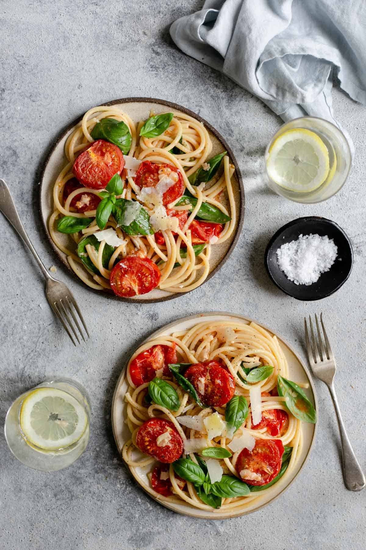 Two plates of bucatini pasta with oven roasted tomatoes #easyrecipe #bucatinipasta 