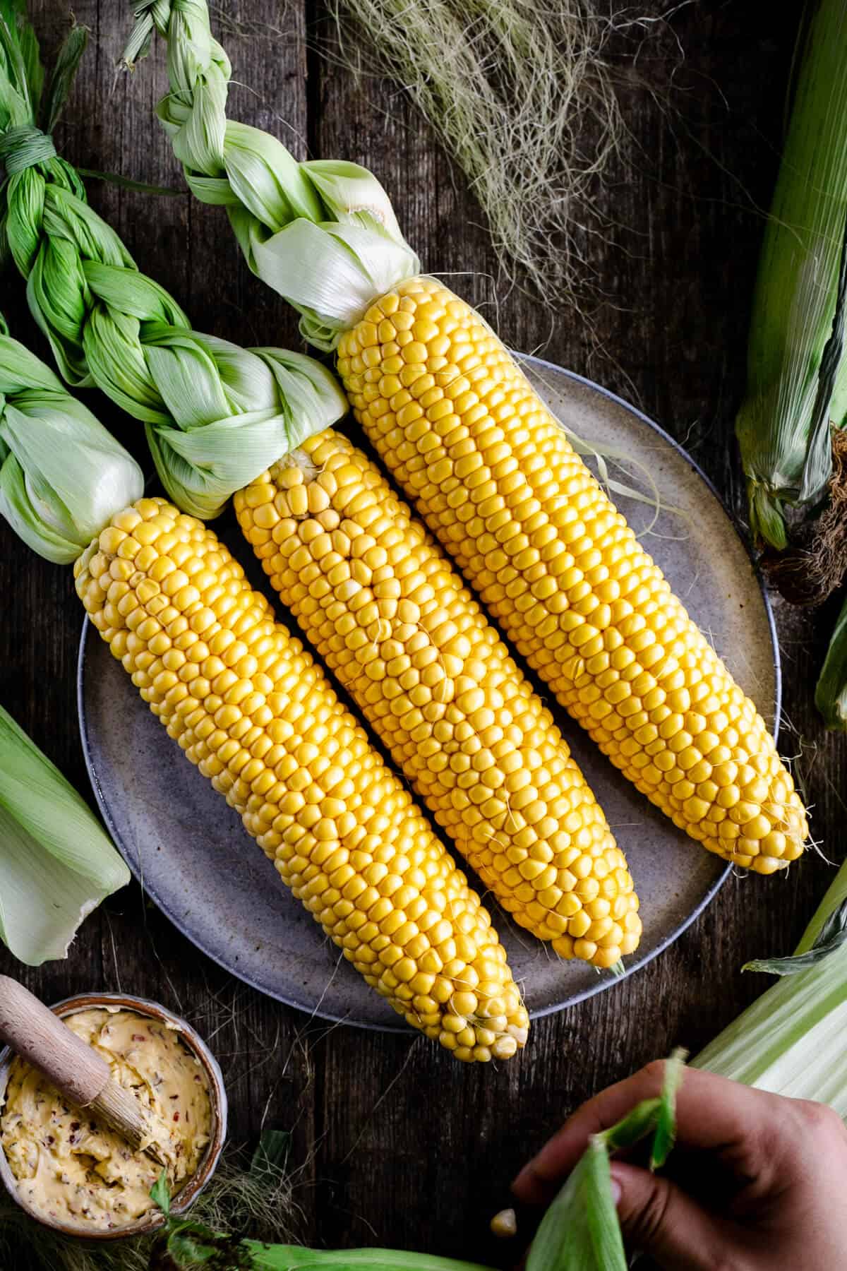 Three fresh cobs of corn on the plate