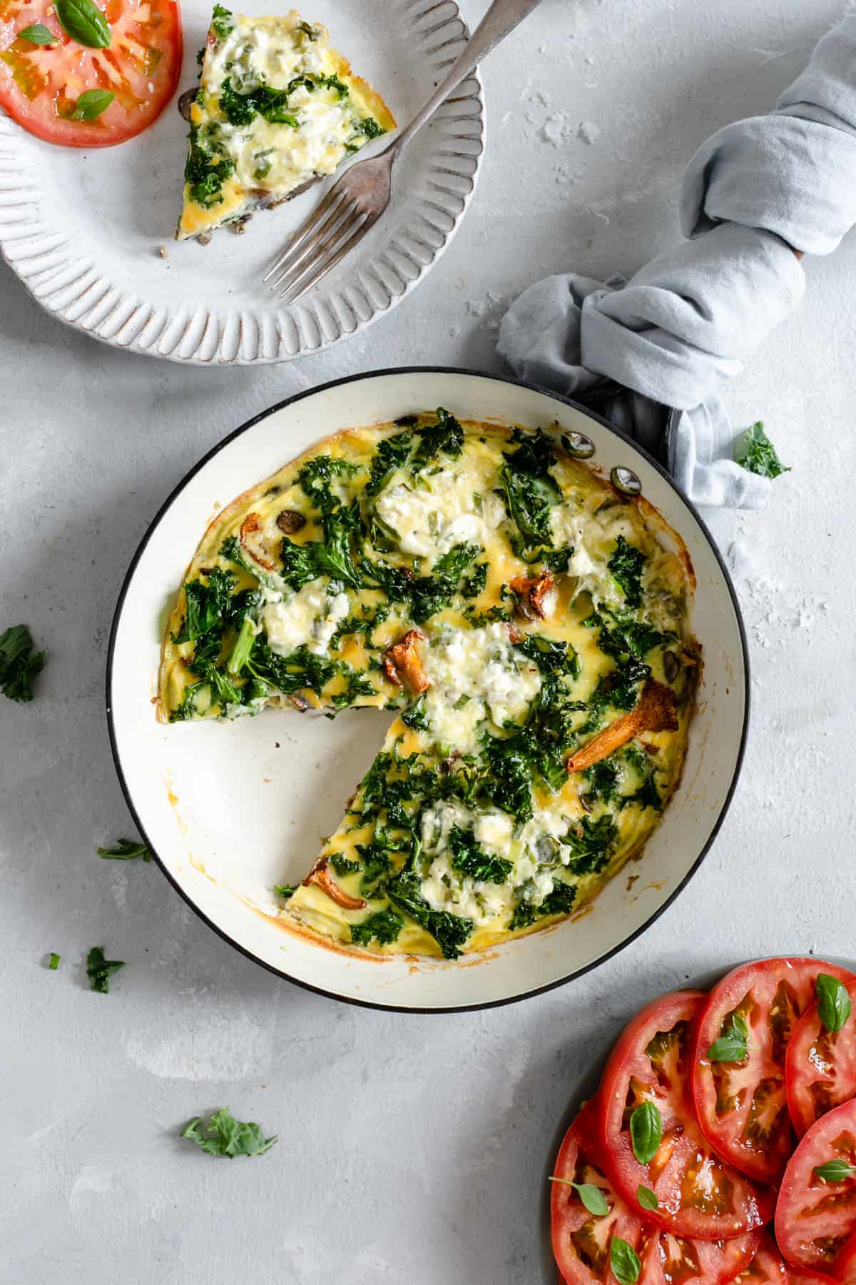Frying pan with mushroom and kale frittata with a slice cut out 