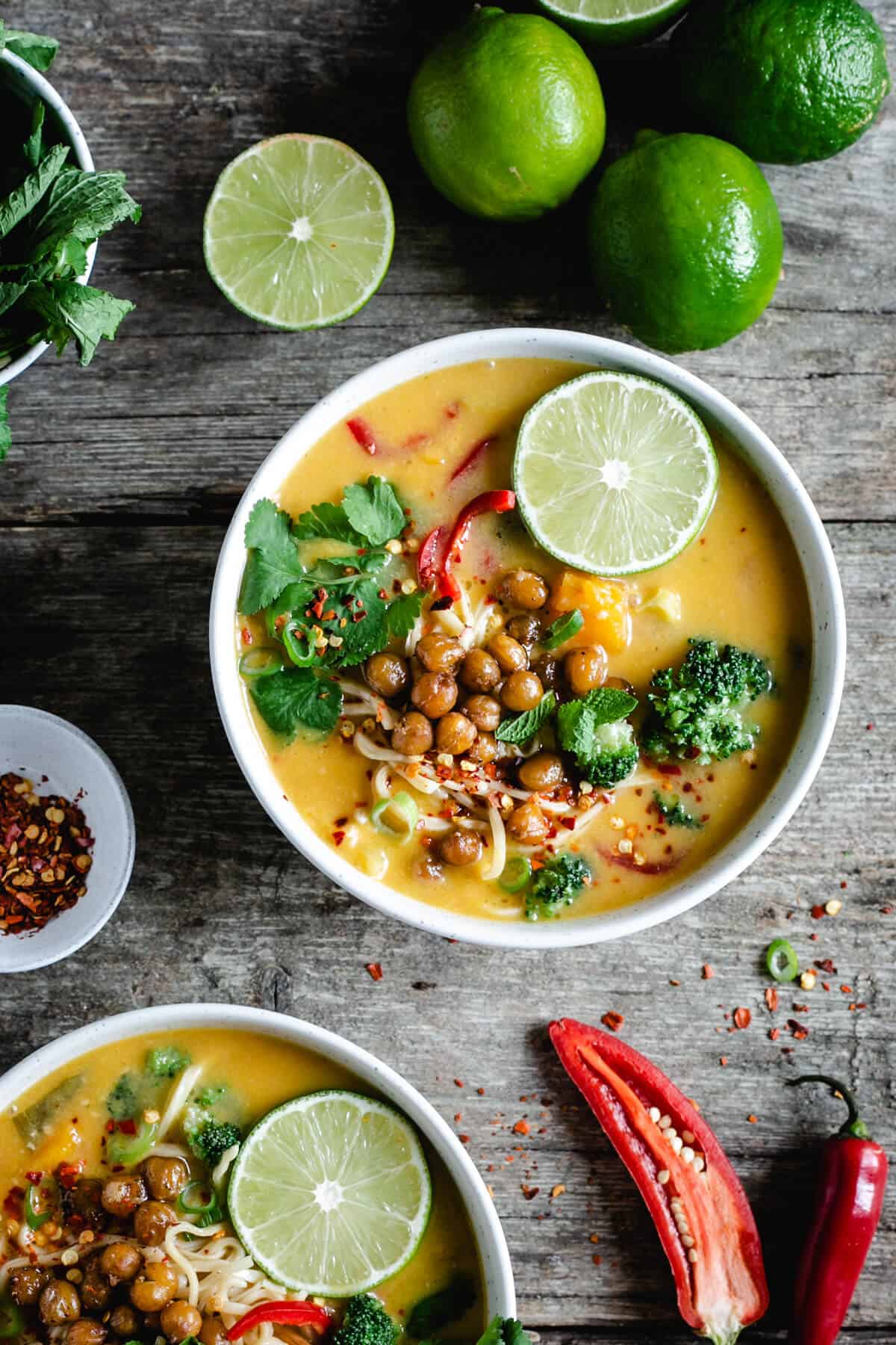 Overhead shot of a small bowl of Thai style pumpkin laksa with crunchy chickpeas and broccoli