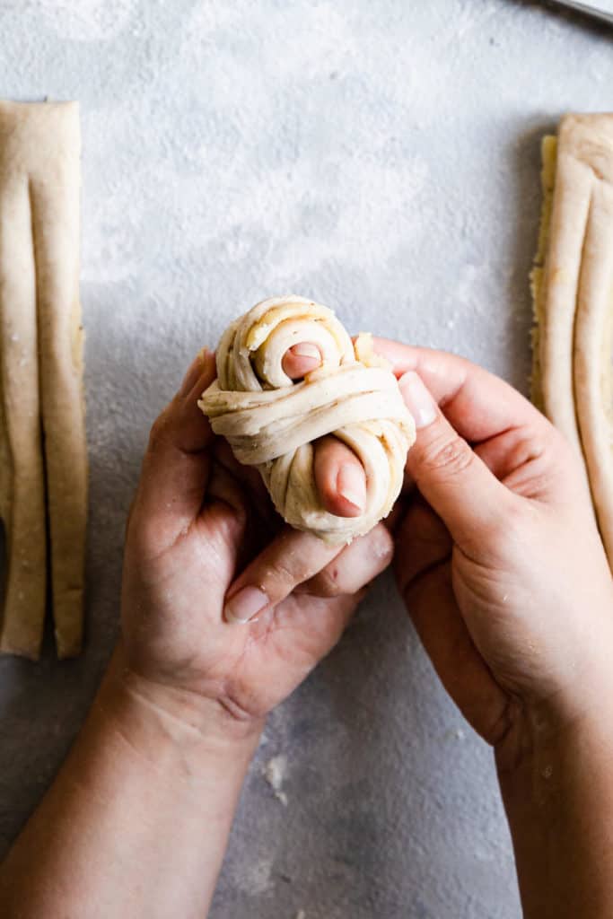 top view of hands shaping the dough into knot