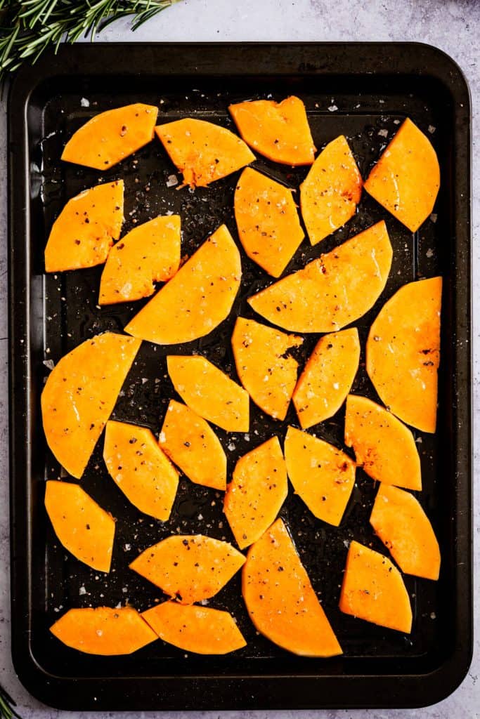 top view of a baking tray with butternut squash wedges