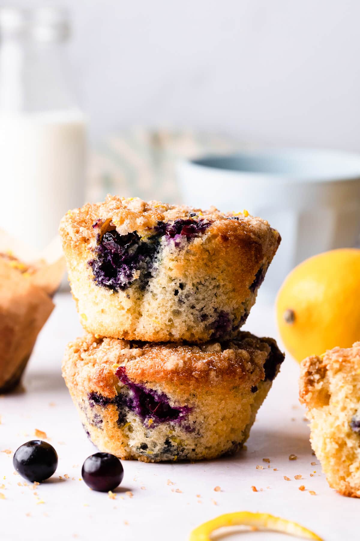 two blueberry lemon muffins without paper cases on top of each other.