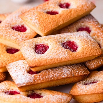 raspberry financiers cakes dusted with sugar and stacked on top of each other.