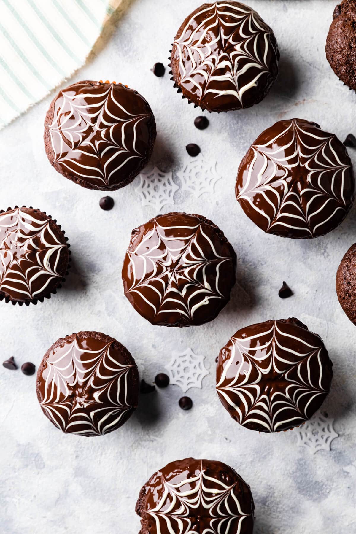 batch of chocolate fudge muffins with spiderweb decorations on top.