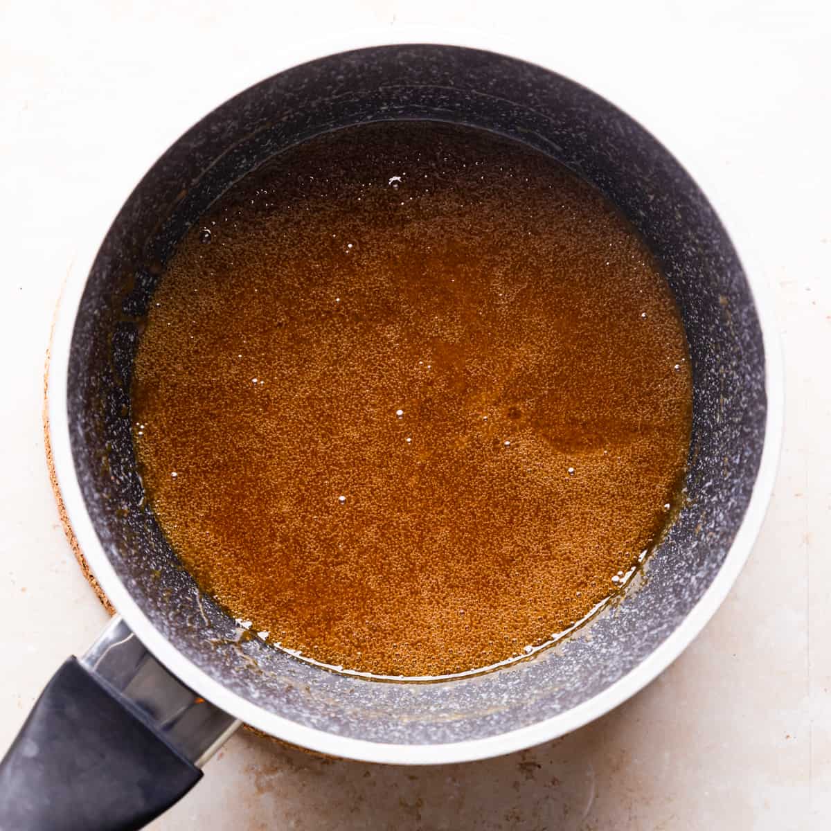 small saucepan with melted butter, sugar and golden syrup mixture inside.