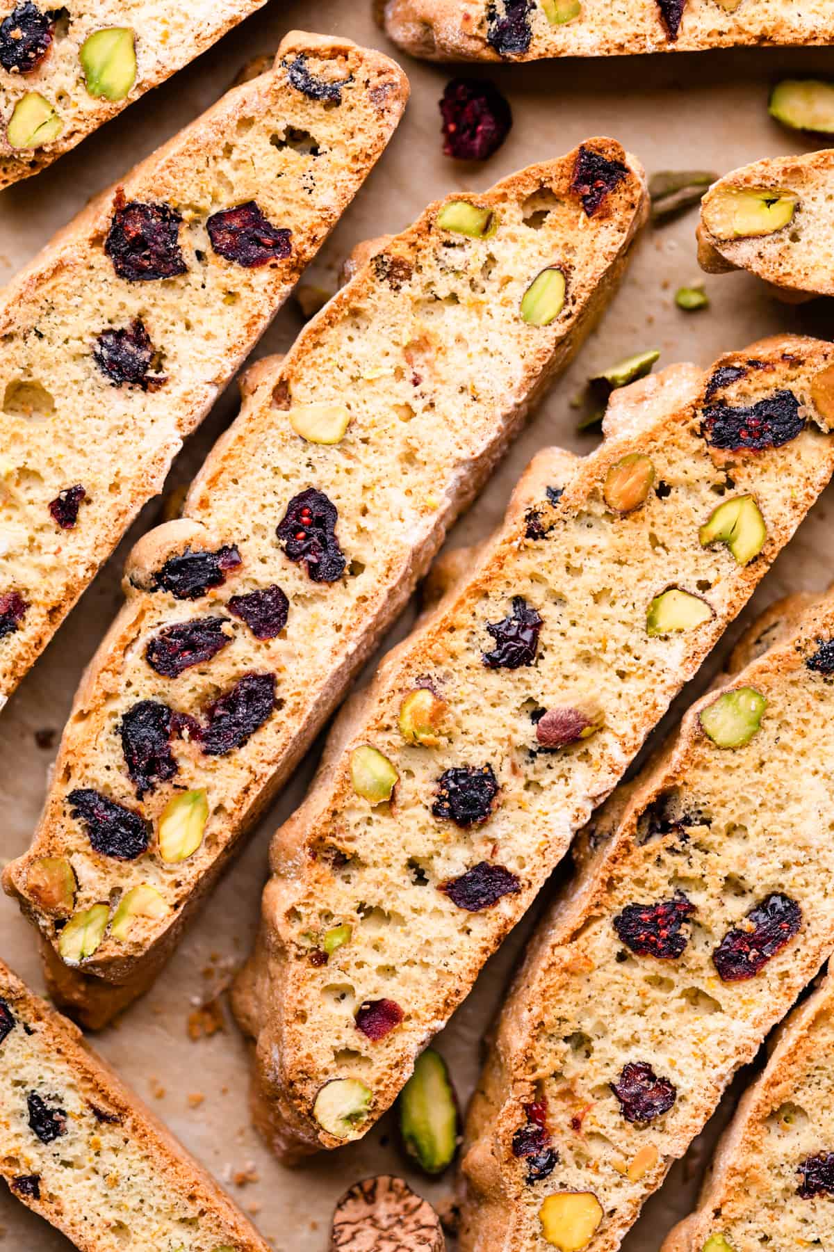 biscotti slices stuffed with dried cranberries and pistachios arranged next to each other.