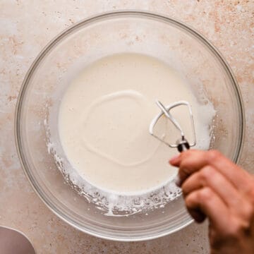 whipped egg and sugar mixture inside of glass bowl.