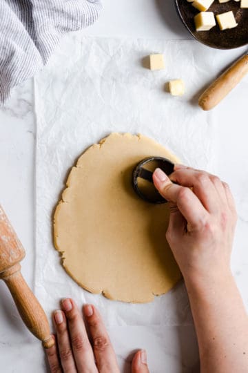 overhead shot of a person cutting cookies out of the dough