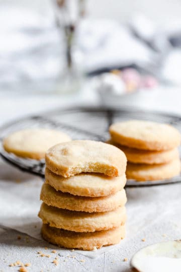 a close up of stack of 5 shortbread cookies with a bite taken out of one