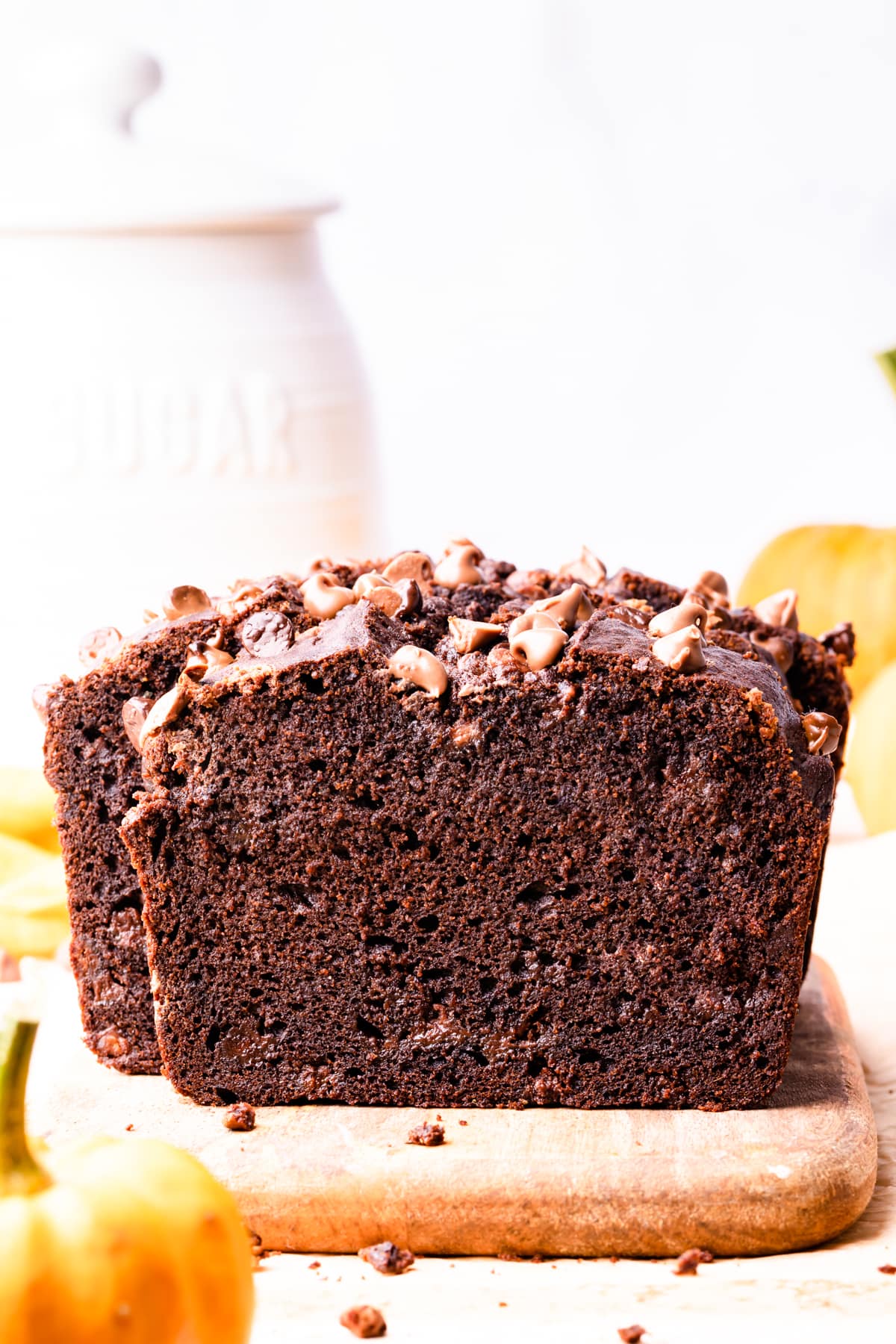 chocolate pumpkin bread with chocolate chips on a small wooden chopping board.