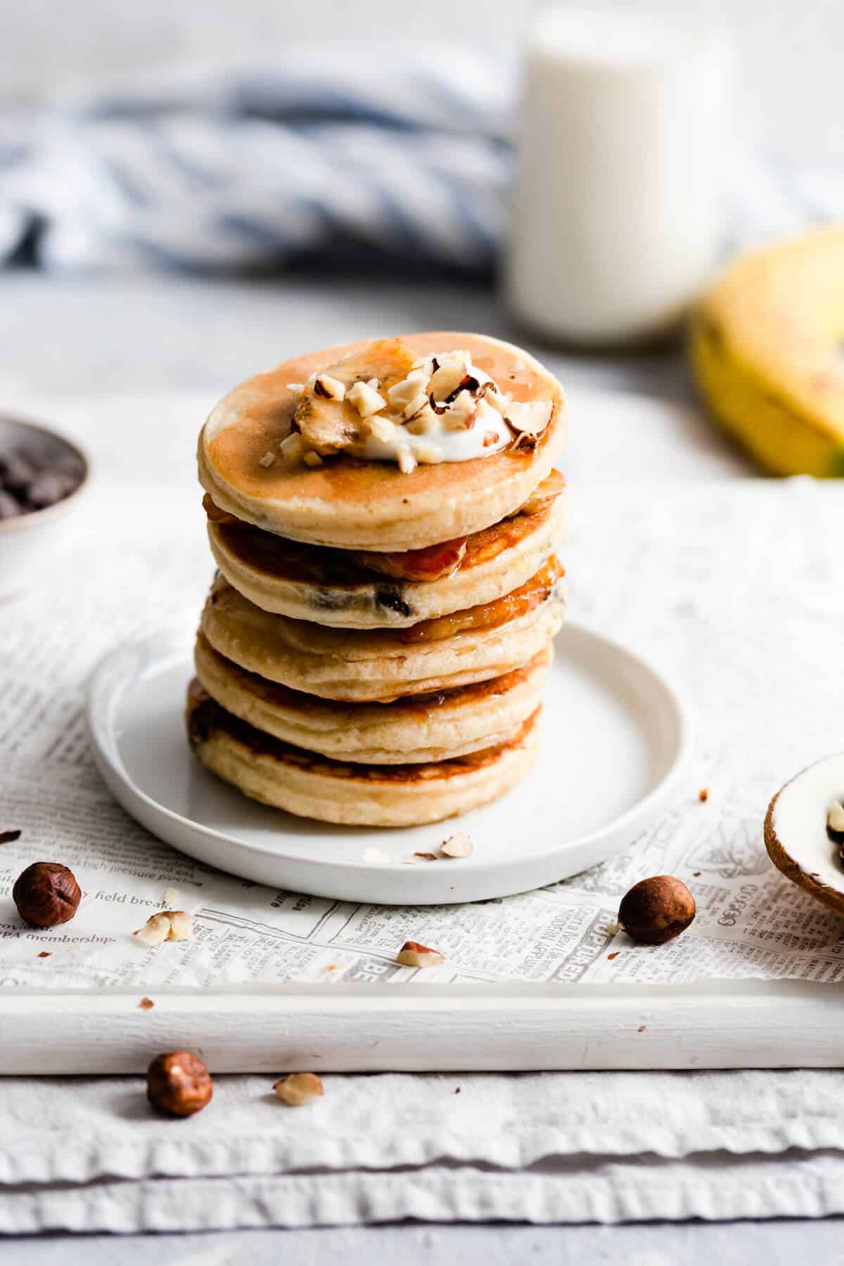 side view of stack of 5 pancakes topped with chopped hazelnuts