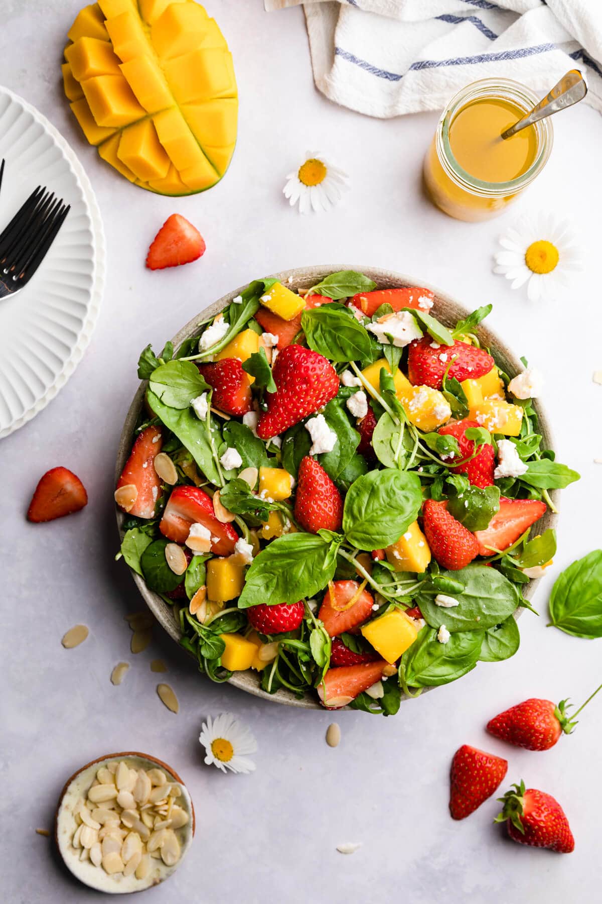 overhead view of strawberry mango salad topped with feta cheese