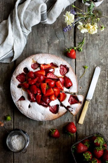 Fresh strawberry yogurt cake covered in icing sugar