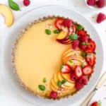 Vegan peach tart with gluten-free crust, topped with summer berries