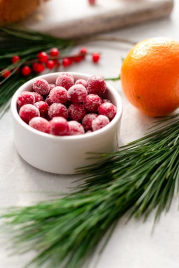 A side shot of a small bowl with sugar covered cranberries