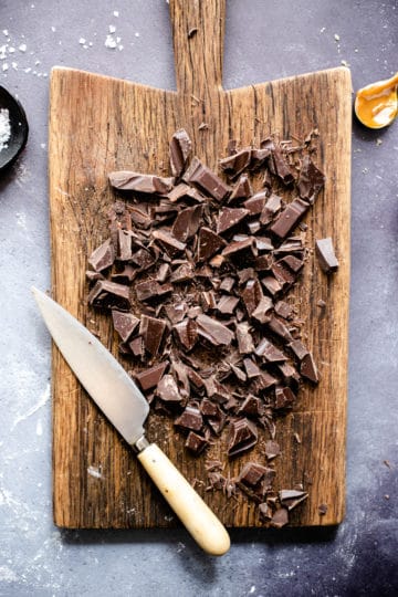 Overhead shot of wooden chopping board with some chopped chocolate on it