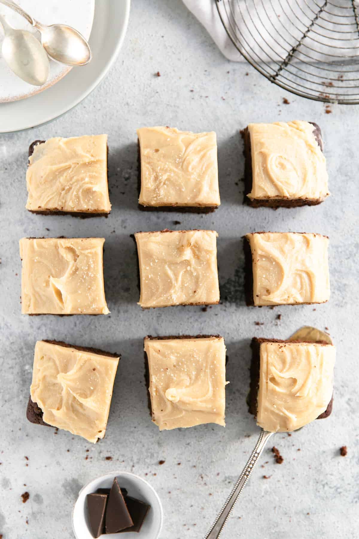 Overhead shot of nine square slices of chocolate brownies with peanut butter frosting