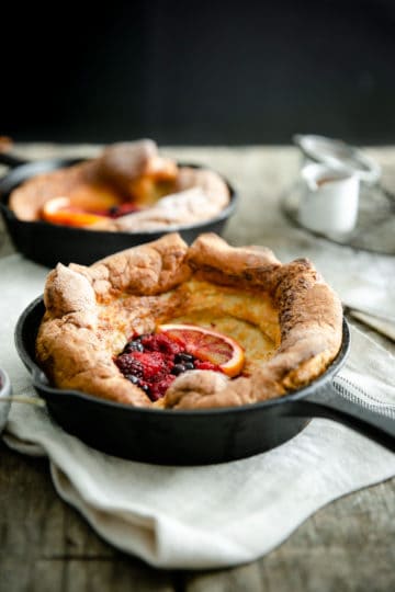 A small skillet with mixed berry dutch baby