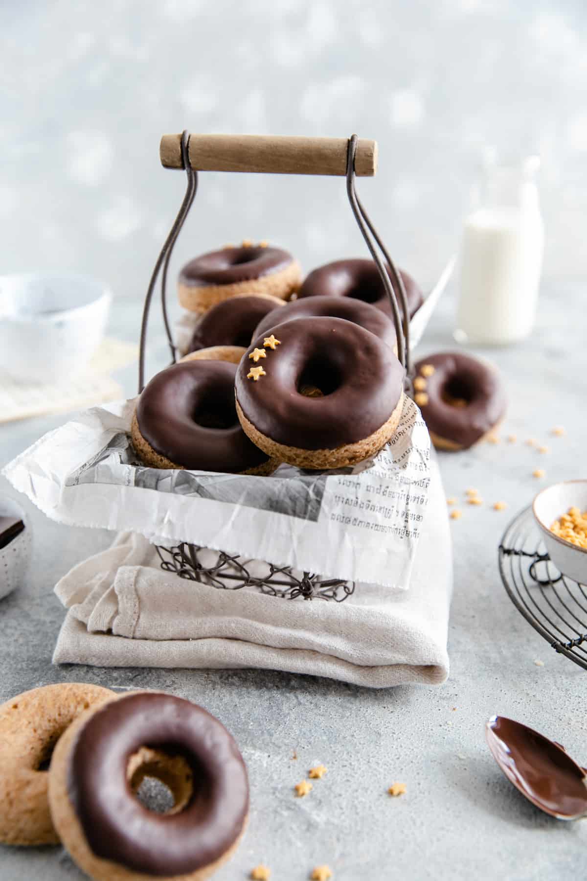 straight ahead shot of small wired basket filled with baked doughnuts with chocolate glaze