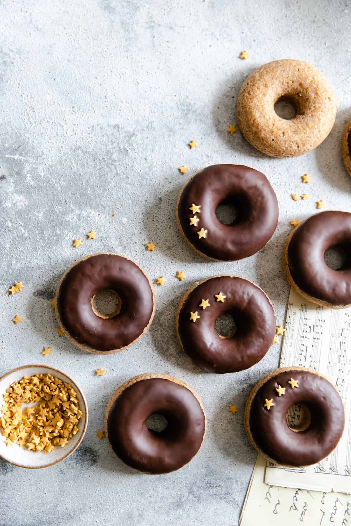 overhead shot of baked doughnuts with chocolate glaze and star-shaped sprinkles