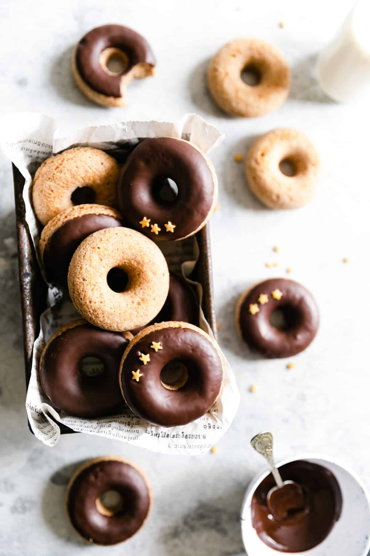 overhead shot of old baking tin filled with baked doughnuts with chocolate glaze