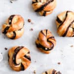 Overhead shot of baked chocolate hazelnut babka buns on a white background
