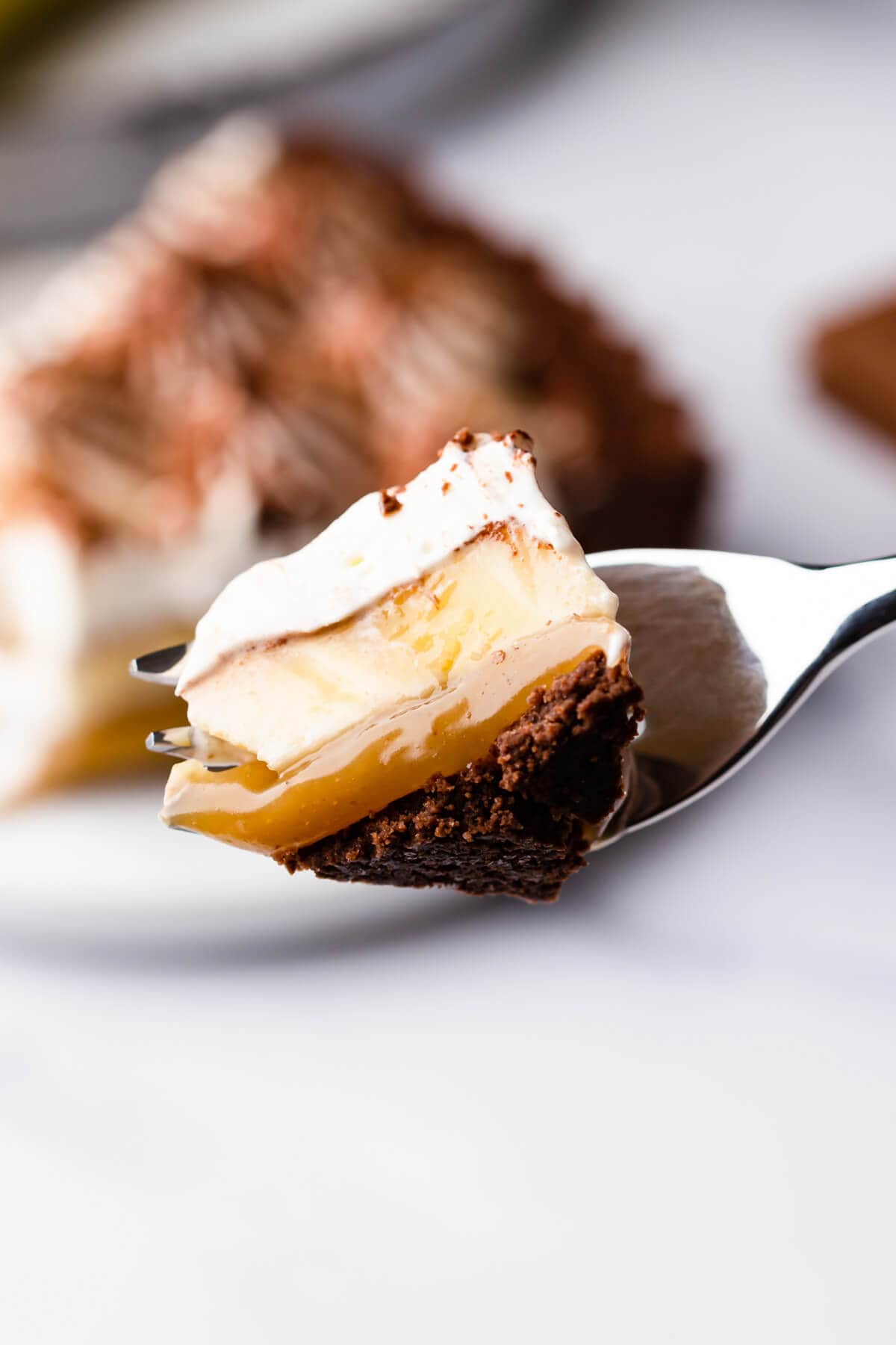 Overhead shot of a chocolate coconut banoffee pie with a slice being cut out