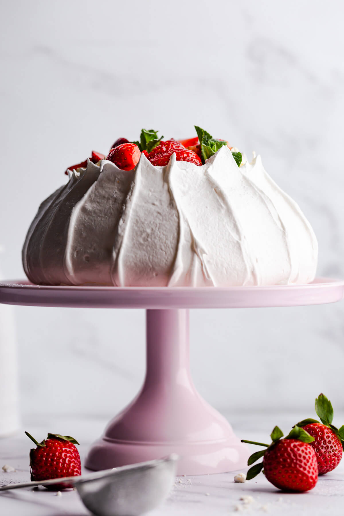 straight ahead view of the pavlova meringue on a pink cake stand