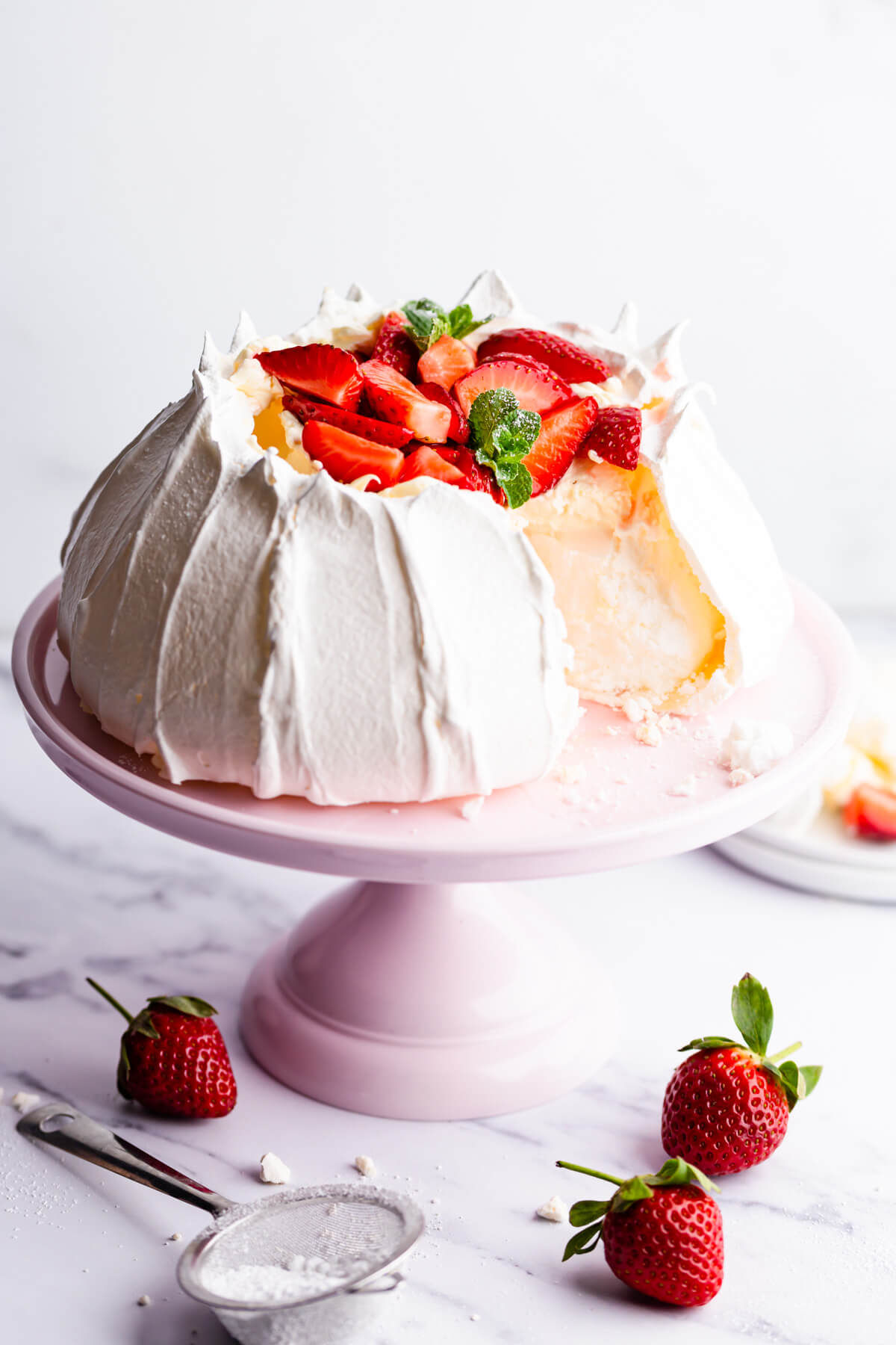 side view of the strawberry pavlova with a slice cut out of it