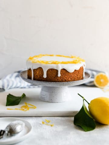a straight ahead shot of a whole lemon cake on a cake stand