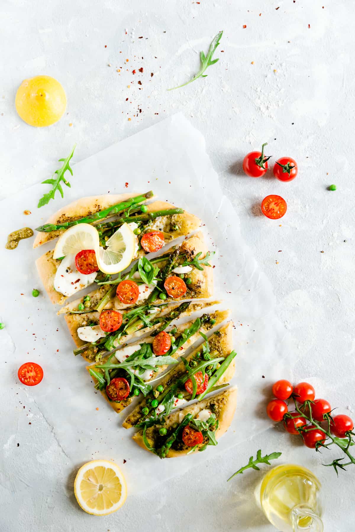 overhead shot of asparagus green pesto pizza cut into slices 