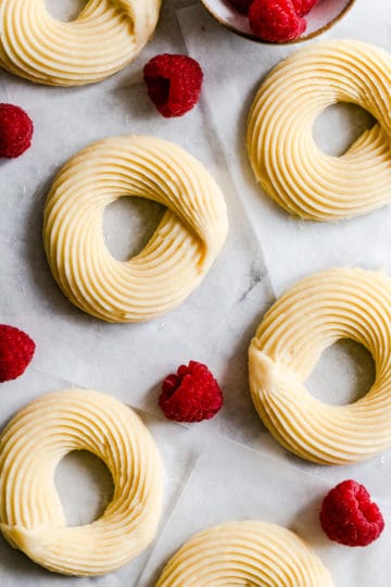 top view close up of raw cruller doughnuts with some raspberries around