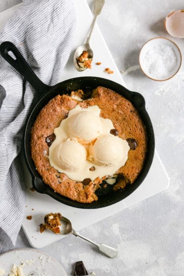 overhead shot of chocolate chip and malted milk skillet cookie with a spoonfull taken out