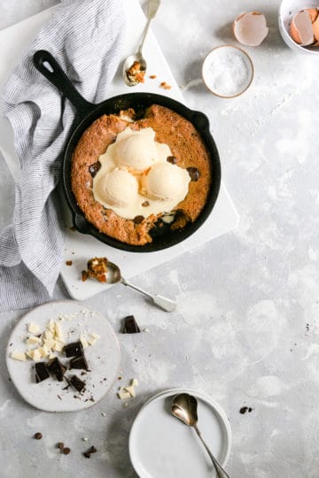 overhead shot of chocolate chip and malted milk skillet cookie with a spoonfull taken out
