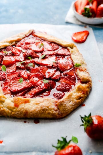 angle shot of strawberry galette with some basil leaves on top
