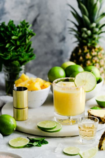 glass of frozen pineapple margarita on a marble chopping board