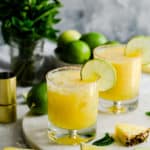 two glasses filled with pineapple margarita cocktail