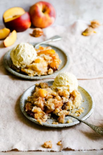 two portions of peach cobbler with some ice cream