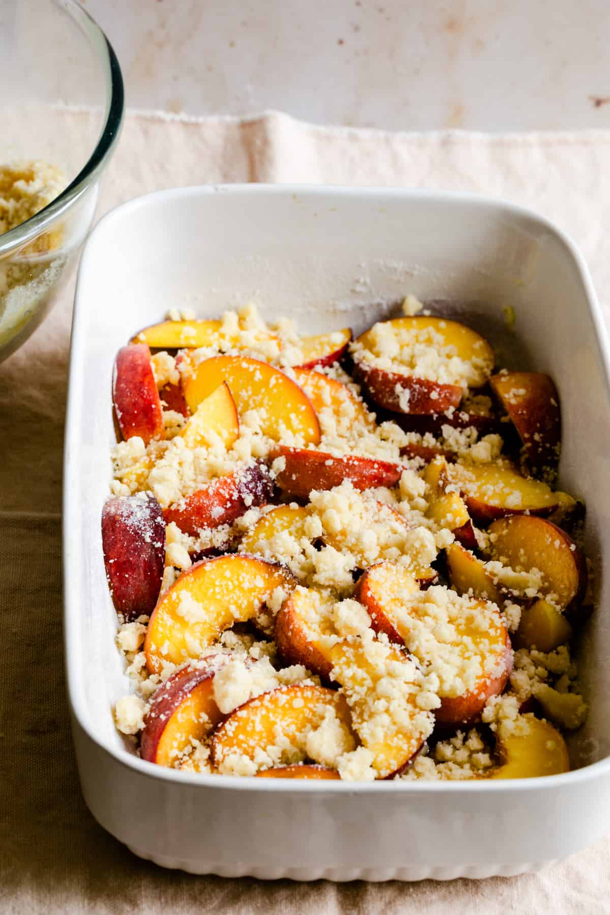 baking dish with sliced peaches and cobbler topping