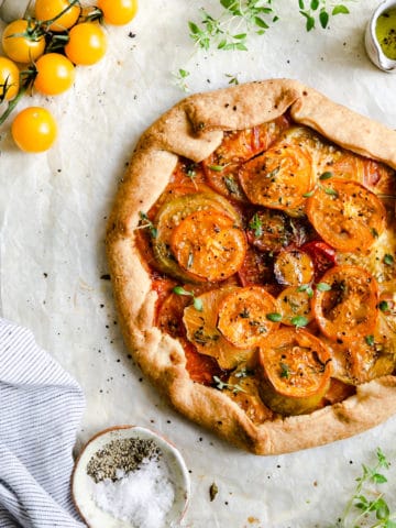 overhead shot of summer tomato galette topped with fresh thyme and black pepper