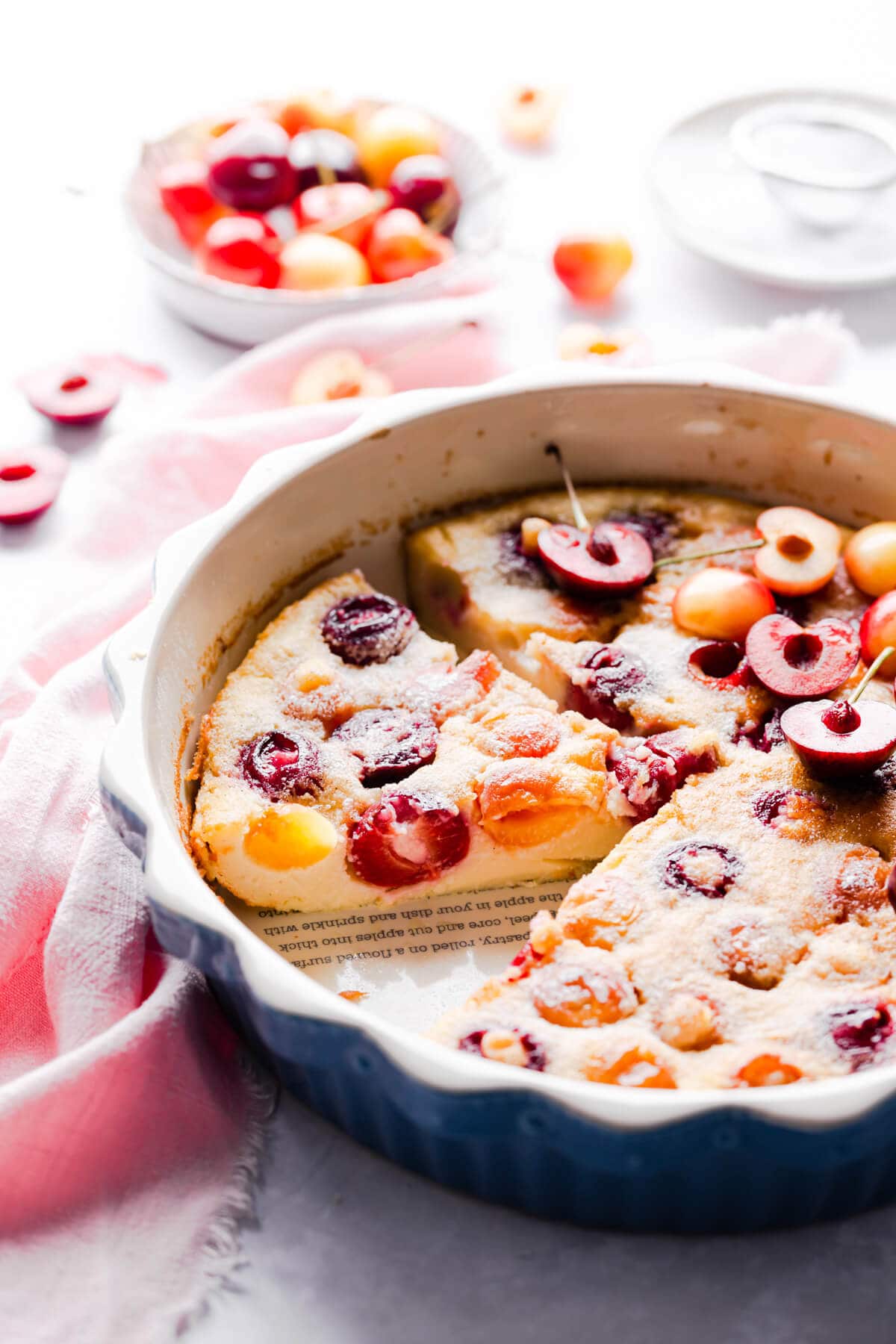 baked cherry clafoutis dusted with icing sugar and topped with fresh cherries