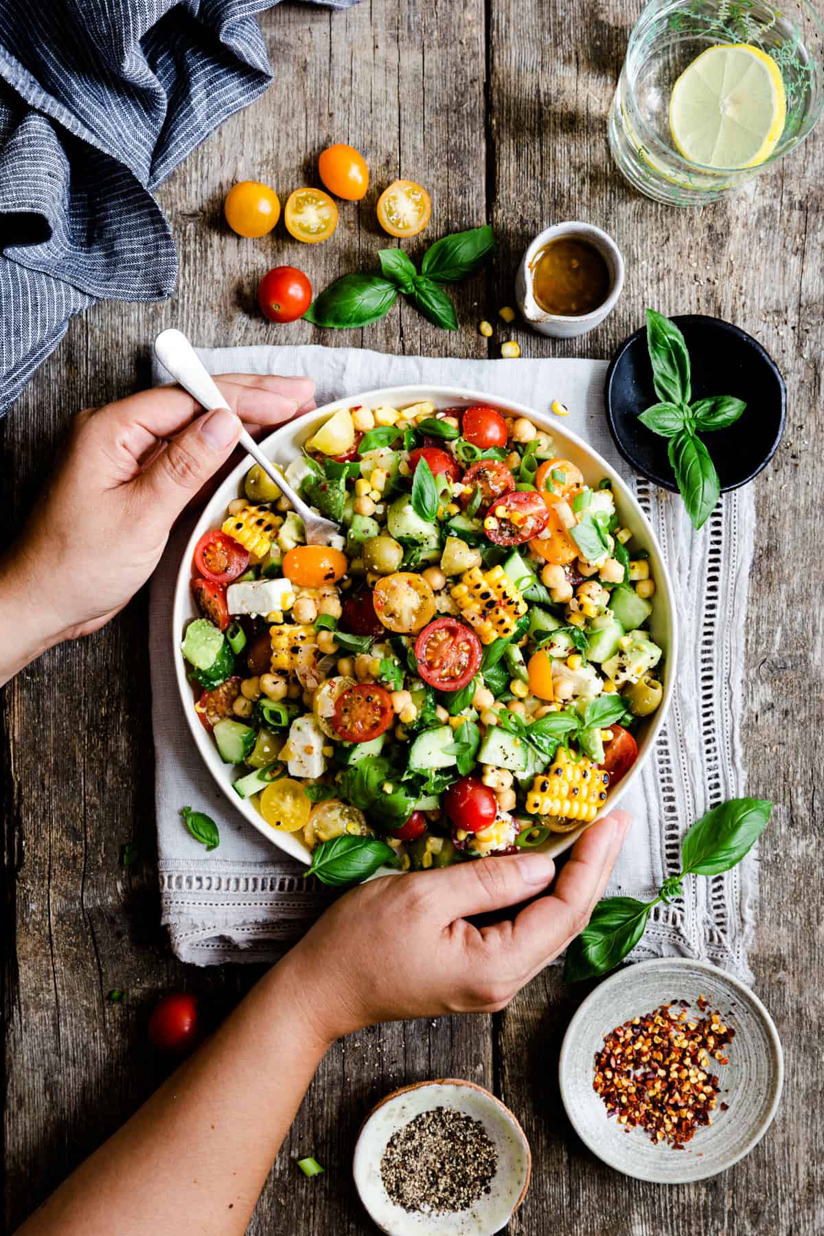 overview of a person holding a bowl with grilled corn and feta salad