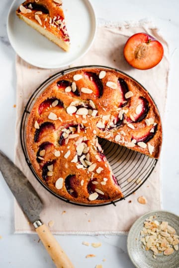 overhead view of plum and almond cake with a slice cut out