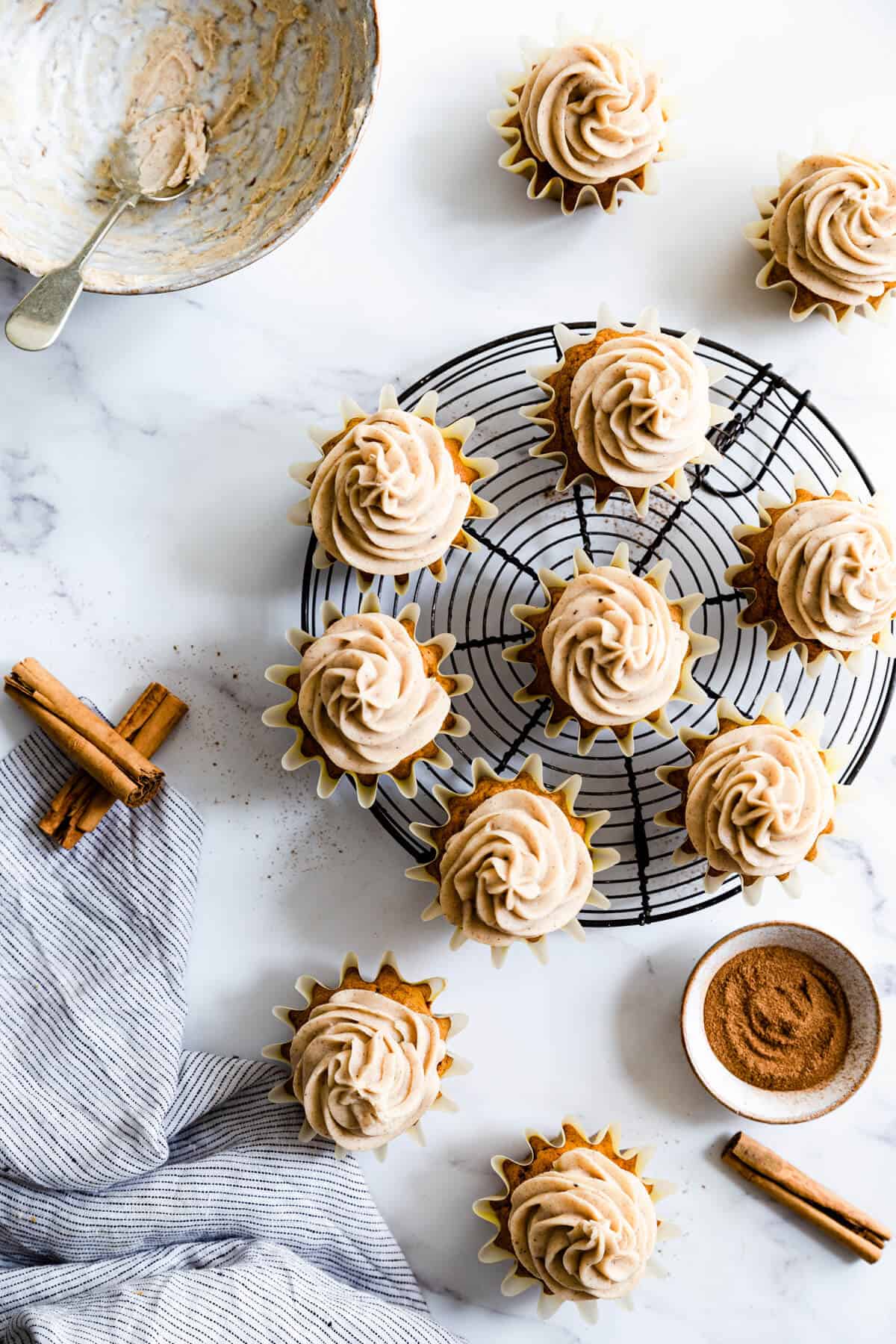 Pumpkin and chai cupcakes arranged on a round cooling rack