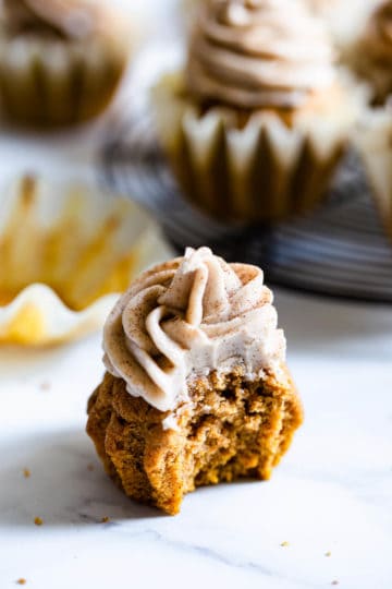 close up of a pumpkin cupcake with bite taken out of it