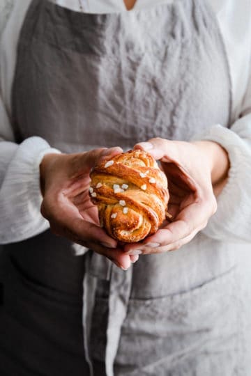 close up of a person holding cardamom bun