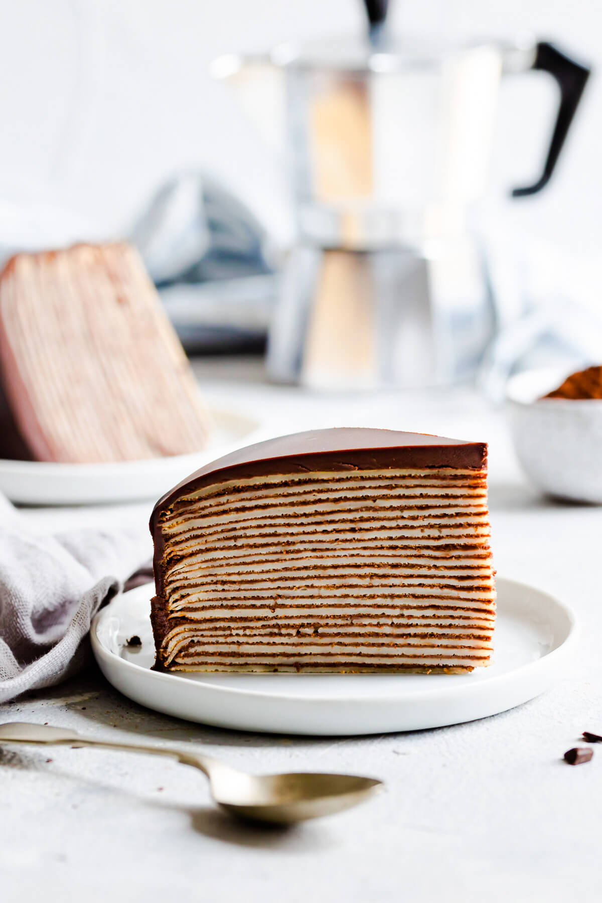 side view of a slice of crepe cake on a small plate