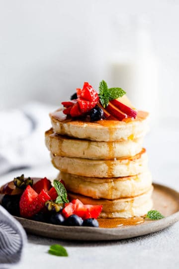 side close up of a stack of 5 fluffy pancakes.
